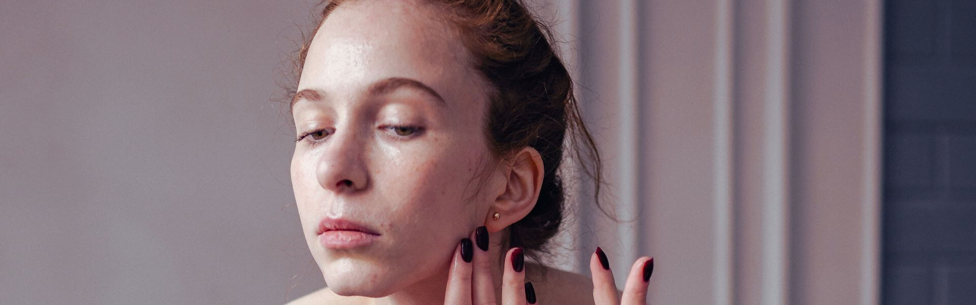 Frau mit empfindlicher Haut betrachtet rote stellen im Gesicht