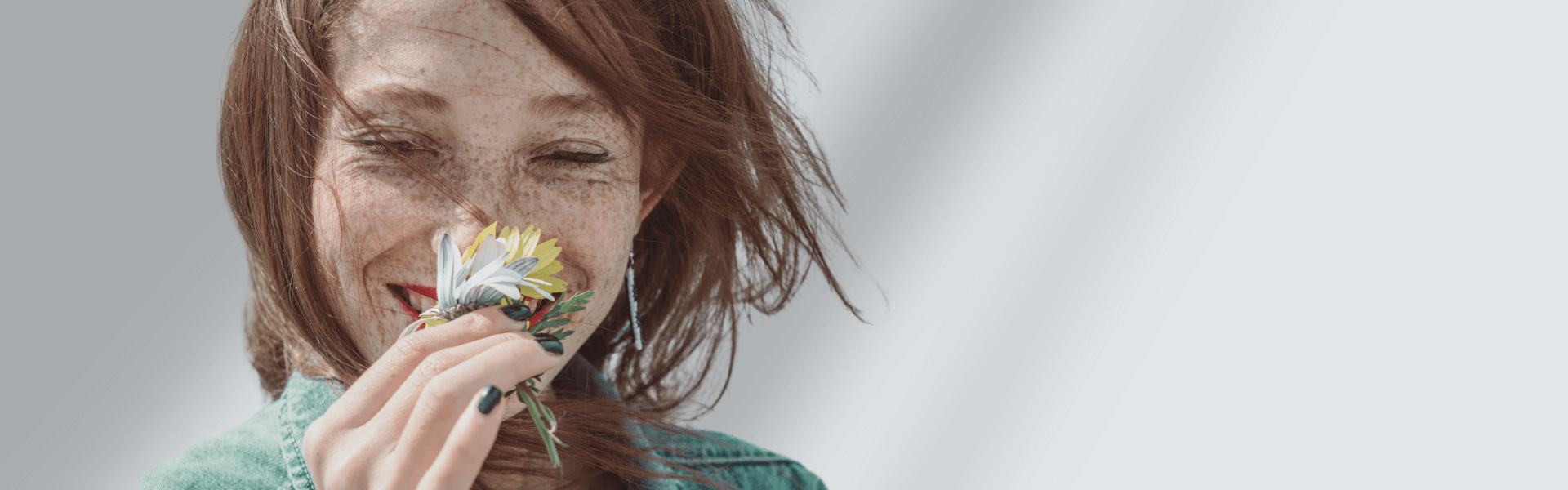 Frau mit Blume im Gesicht genießt entspannte Hautpflege – SOTHYS Behandlungskonzepte für individuelle Pflegeroutinen bei jedem Hauttyp