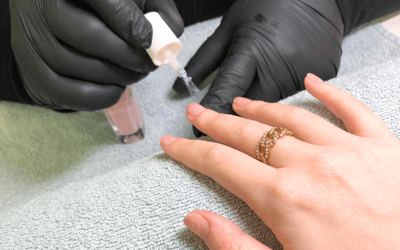 Professionelle Maniküre: Nägel werden mit Pastell-Lack lackiert