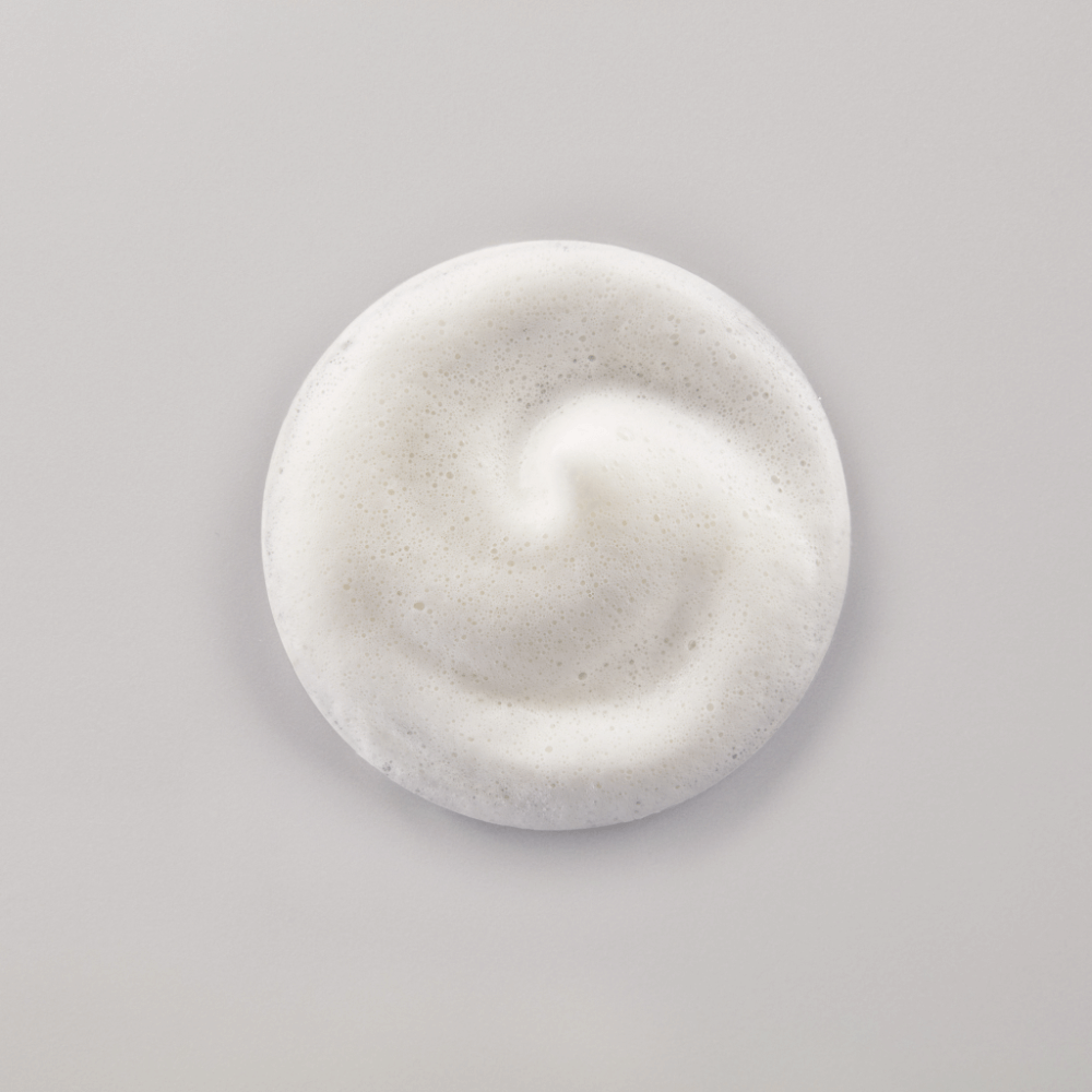 Leichter, cremiger Schaum des QMS Exfoliating Body Foam – sanft peelend und feuchtigkeitsspendend.