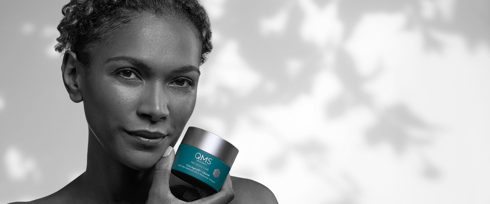 Frau mit QMS Collagen-Creme in der Hand – hochwirksame Anti-Aging-Pflege für straffe, regenerierte und jugendlich aussehende Haut.