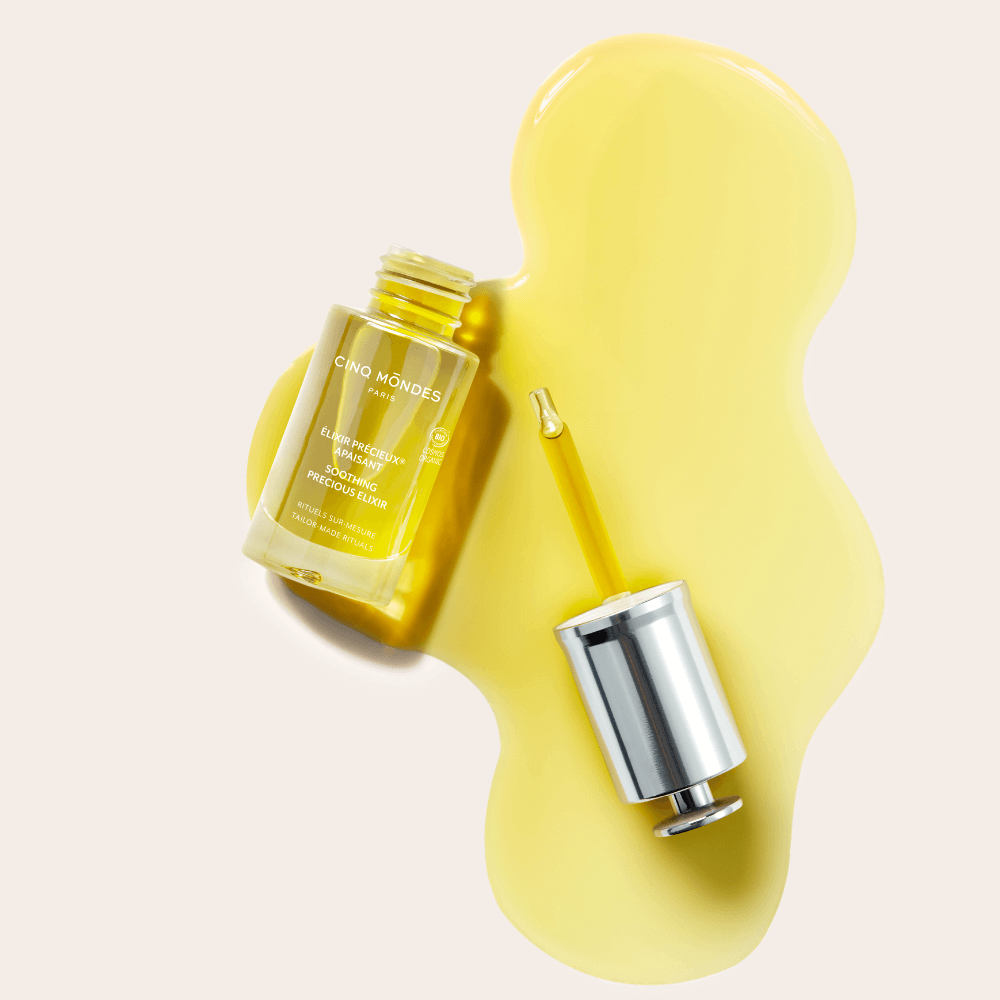 Cinq Mondes Élixir Précieux Apaisant 15 ml – beruhigendes Gesichtsöl-Serum, geöffnet mit Pipette, goldgelbe Öltextur für sensible Haut