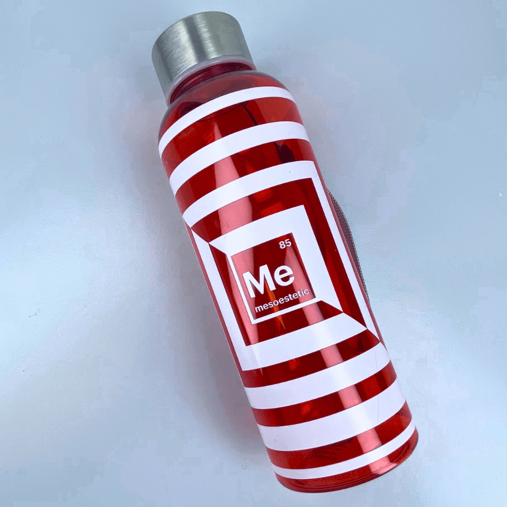Mesoestetic Trinkflasche liegend – modernes Accessoire im orange-weiß gestreiften Design, ideal für Studio, Büro oder unterwegs.