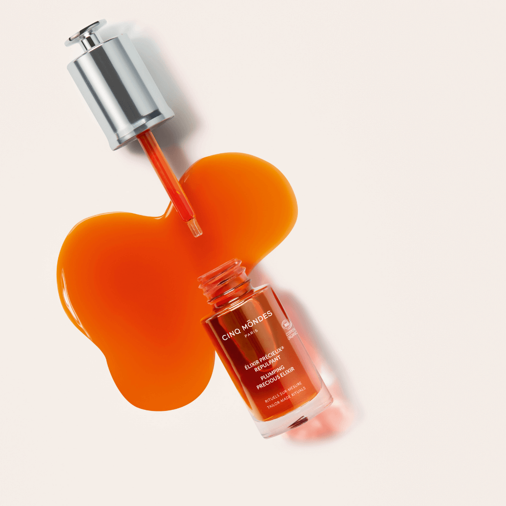 Cinq Mondes Élixir Précieux Repulpant – Anti-Aging Gesichtsserum in Ölform, mit Pipette und goldorangener Textur, inspiriert von Ritualen aus China