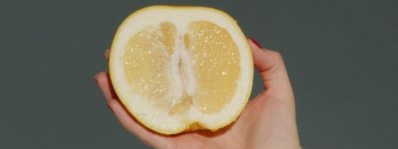 Halbe Zitrone in einer Hand
